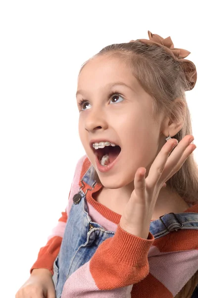 Ortodonti aletli küçük bir kızın portresi beyaz arka planda izole edilmiş..