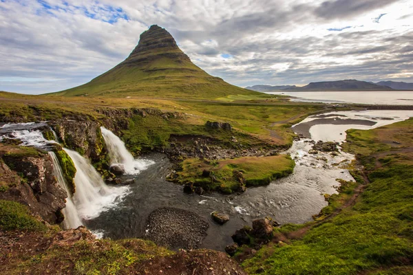 Letní zamračený den s Kirkjufell sopka na pobřeží Snaefellsnes poloostrova. Idylická scéna Kirkjufellsfoss vodopádu, Island, — Stock fotografie