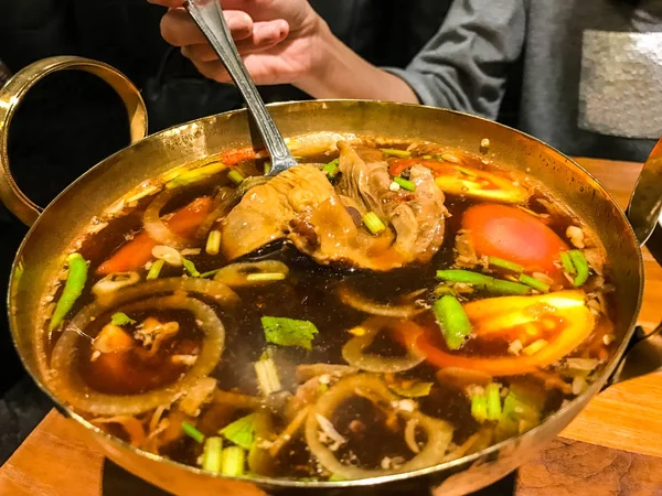 Comida tradicional de sopa de ervas tailandesa autêntica em latão panela quente: Sopa de porco quente e azeda em panela quente, Sopa de porco Tom Yum, Tomyam Moo Toon . — Fotografia de Stock