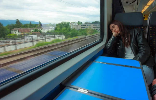 Mujer asiática mira fuera de la ventana del tren, buscando aburrido o cansado de viajar demasiado tiempo . —  Fotos de Stock