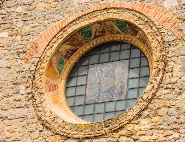 Un fresco del siglo XIV cubierta de vidrio y el rosetón de la encantadora gótico iglesia de San Jorge (Chiesa di San Giorgio) en Varenna, lago Como, Italia. — Foto de Stock