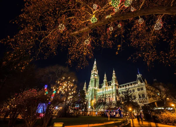 Kolorowe światło świeci noc Jarmark bożonarodzeniowy z tłumu ruch niewyraźne w wiedeńskim ratuszu w Europie Rathausplatz, Austria,. — Zdjęcie stockowe
