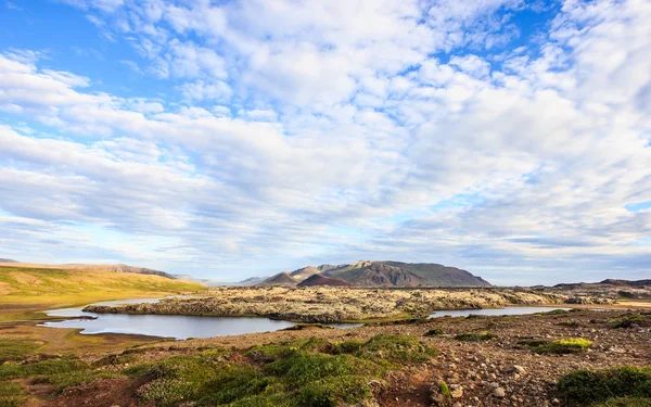 Wunderschöne sommerliche isländische Landschaft mit Grasland, farbenfrohen Bergketten und schönem Himmel als Hintergrund. Island, Europa — Stockfoto