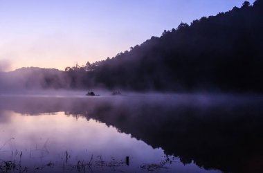 Çevre dostu açık hava etkinliği, yüzen Bamboo Rafting sabah sakin göl güneş ışığı ve sis su Vadisi ve dağ aralıkları, Pang Oung, Mae Hong Son, Tayland çevrili ile
