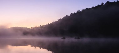 Çevre dostu açık hava etkinliği, yüzen Bamboo Rafting sabah sakin göl güneş ışığı ve sis su Vadisi ve dağ aralıkları, Pang Oung, Mae Hong Son, Tayland çevrili ile