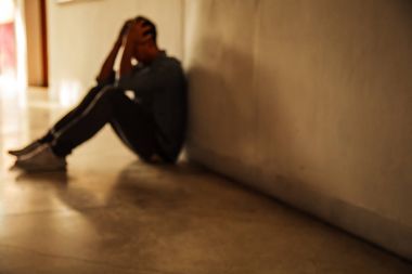 Duygusal bir an: oturan adam kötü, depresif, hayal kırıklığına, umutsuz hissediyorum zihinsel problemleri üzgün genç erkek vurguladı kafa elele. Umutsuz adamın yardıma ihtiyacı karanlık köşesinde.