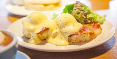 Seçici odaklı yumurtalı Benedict sandviçi, haşlanmış yumurta, pastırma ya da jambon ve holandez soslu İngiliz çöreğinden oluşur. Amerikan kahvaltısı ya da brunch yemeği. Sabah yemeği kavramı