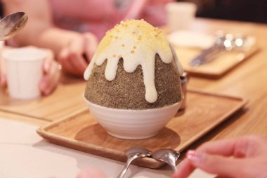 Kore usulü buzlu dondurma (bingsu veya bingsoo) tatlı, yoğunlaştırılmış süt ve tatlı karamel şurubu ile tatlandırılmış Japon çayı. Geleneksel Asya atıştırmalıkları, tatlılar, ikramlar ve yiyecek konsepti.