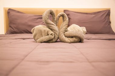 Romantic Bedroom Interior, Kissing Swan Origami Towels decoration on the hotel room bed for newlywed couple. Wedding, Valentine, Anniversary, Honeymoon, Craft, Accommodation, Love and Symbol concept