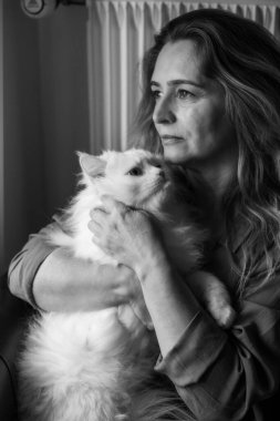 Kedisiyle birlikte bir kadının resmi.