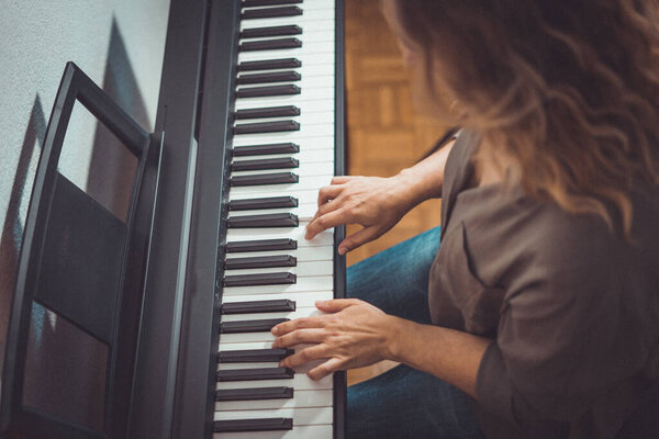 Красивая женщина играет на пианино дома в ограниченные дни
