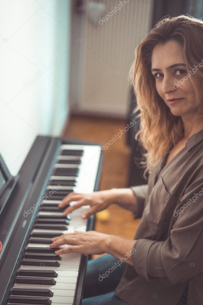 Pretty woman play the piano in home at confined days