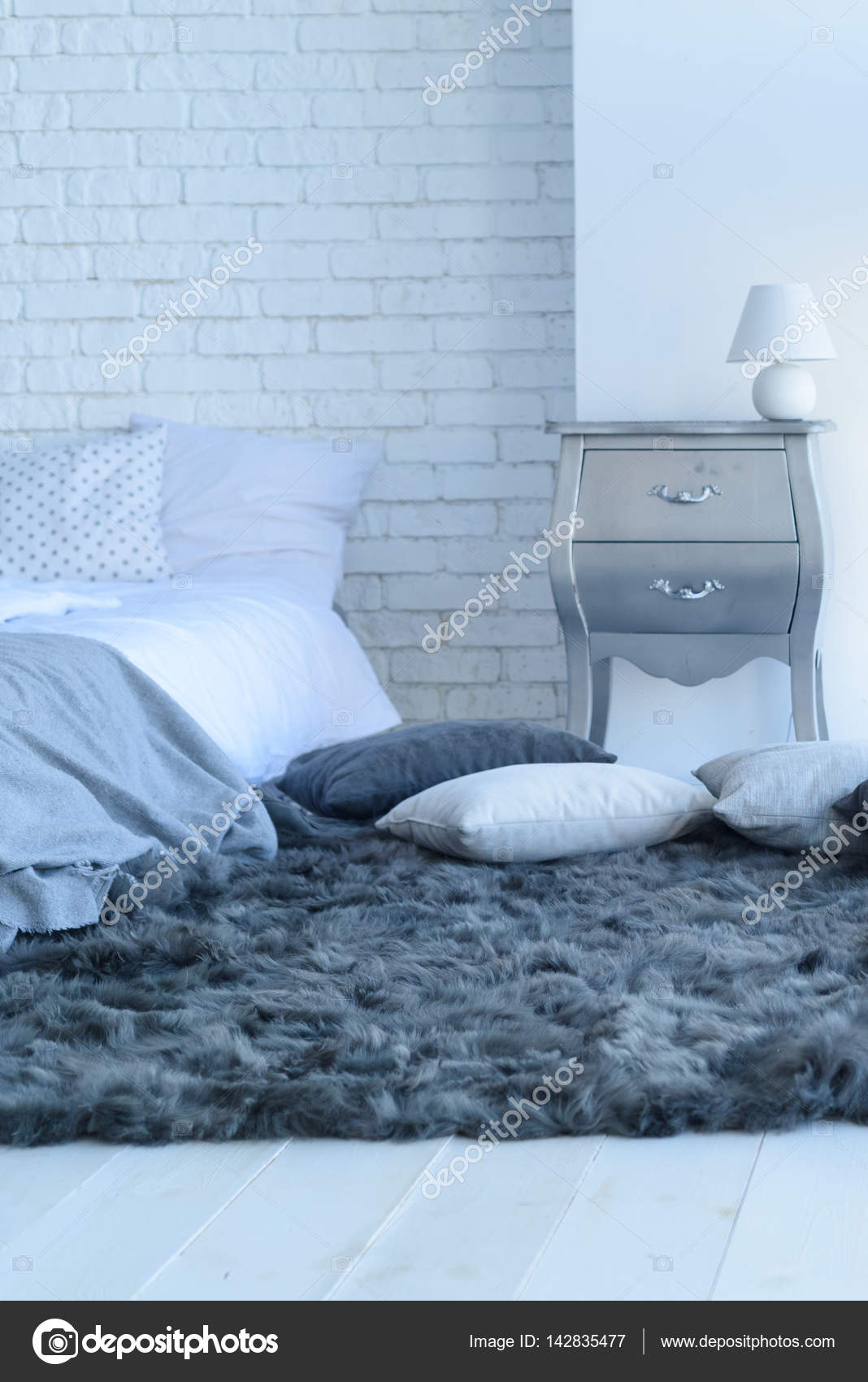 Interno camera da letto con un muro di mattoni con un letto e ... Interno camera da letto con un muro di mattoni con un letto e ...