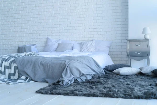 Інтер'єр спальні з цегляною стіною з ліжком і тумбочками — стокове фото