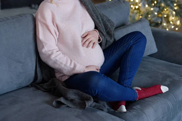 Ragazza incinta si siede su un divano — Foto Stock