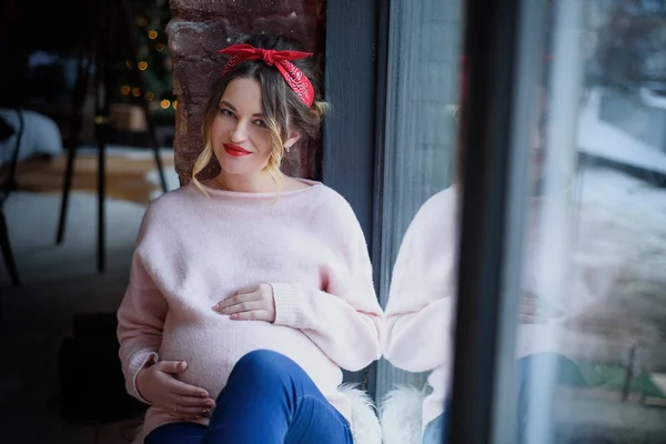 Dziewczyna w ciąży siedzi w pobliżu okna — Zdjęcie stockowe