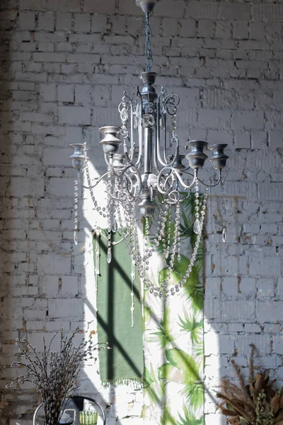 Vintage crystal chandelier and silk canvas with tropical print pantone greenery