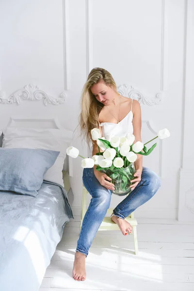 Atrakcyjna Dziewczyna Łóżku Niebieski Wnętrza Sypialni Białe Tulipany — Zdjęcie stockowe