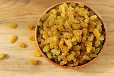 Bir tabak ve ahşap arka plan üzerinde altın üzüm