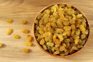 Bir tabak ve ahşap arka plan üzerinde altın üzüm