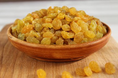 Bir tabak ve ahşap arka plan üzerinde altın üzüm