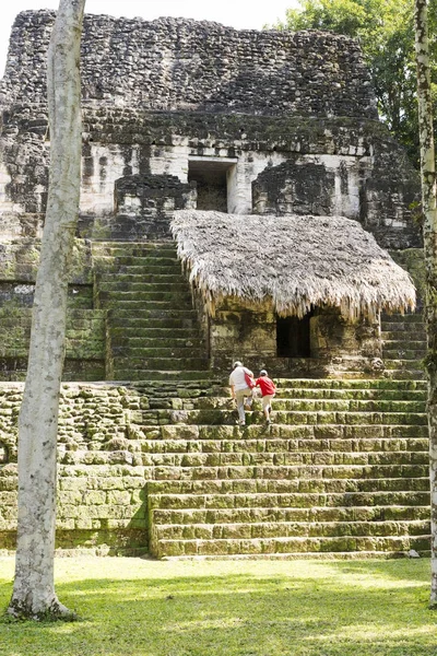 Turistas en las ruinas del templo en Tikal —  Fotos de Stock