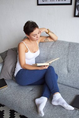 Kız oturmuş kitap okuyor.