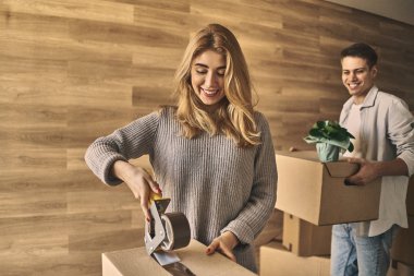 Çekici bir çift, taşınmak için karton bir kutu hazırlıyorlar.