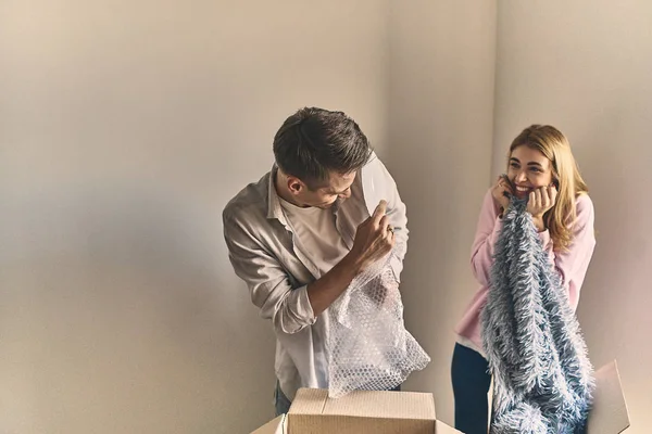 Lovely couple having fun and enjoying and unpacking tableware af — Stock Photo, Image