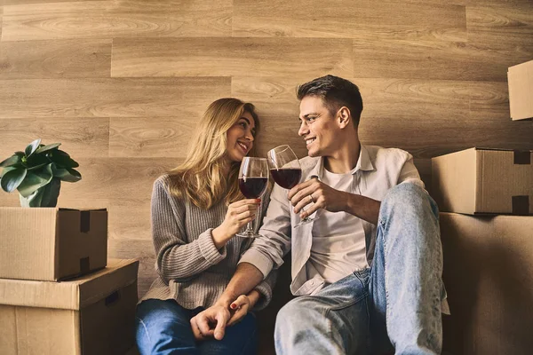 Happy lovely couple celebrating moving to new house with glass o — Stock Photo, Image