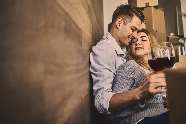 Happy lovely couple celebrating moving to new house with glass o — Stock Photo, Image