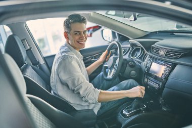 Stylish man sitting a new car and getting ready to drive.