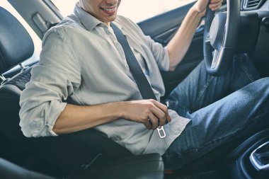 Stylish man sitting a new car and getting ready to drive.