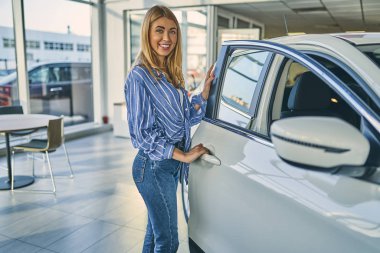 Cheerful girl choosing a new car.