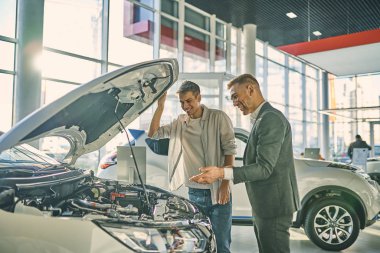 Business concept. Serious manager presenting a new car to handso