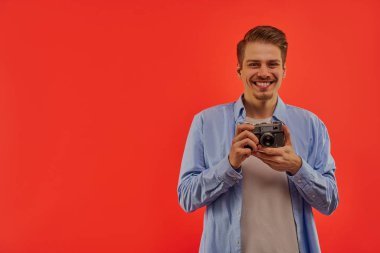 Mutlu adam elinde bir kamera tutuyor..