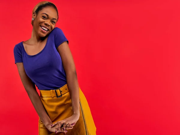 Happy lady with wide smile in a t-shirt in a skirt looks at the camera