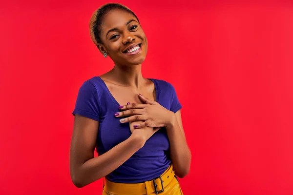 Happy lady with wide smile in a t-shirt in a skirt looks at the camera