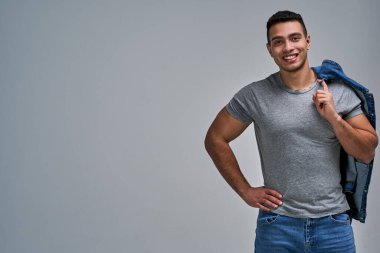 Yüzünde kılları olan mutlu, atletik yapılı bir adam.