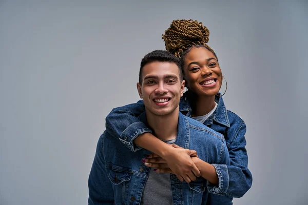 Woman in earrings and a man in denim jackets with smiles
