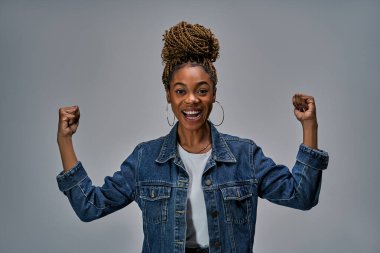 Yüzünde mutlu bir ifade olan kadın yumruklarıyla zafer işareti yapıyor..