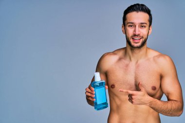 Elinde diş fırçası ile bronzlaşmış mutlu bir adam.