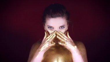 4k Studio bir altın Glittery vücut kadın silerek yüzüne vurdu