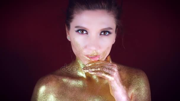 4k studio colpo di un dorato glitter corpo donna pulire il suo viso — Video Stock