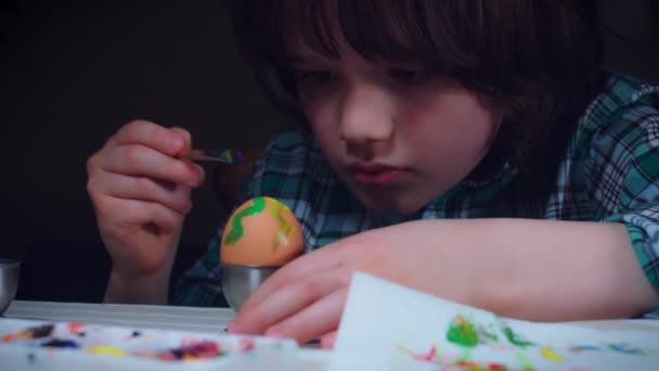 4K casa tiro de niño pintura huevos de Pascua — Vídeo de stock