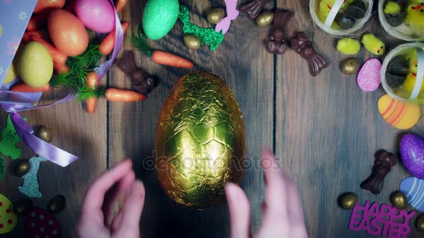 Composición de Pascua 4K desde arriba de las manos desenvolviendo el huevo — Vídeo de stock