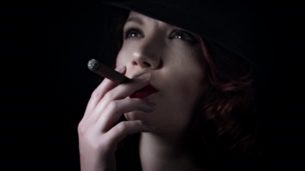 Девушка курит на черном фоне — стоковое видео