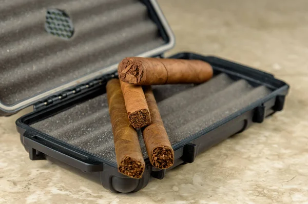 Cigars on top of a black travel humidor. Rich smelling and textu