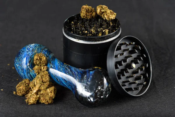 Närbild på medicinsk marijuana bud med ett glas röret och grinder — Stockfoto