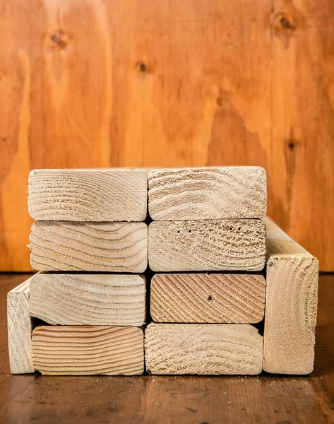 A stack of dried pine boards with a stained wood background